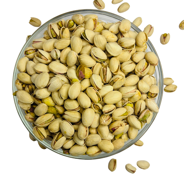 Nuts For Wellness Pistachios in a glass bowl on a white background