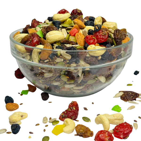 Nuts For Wellness Glass bowl filled with a mix of nuts, seeds, and dried fruits on a white background