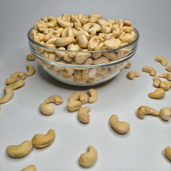 Glass bowl filled with cashews on a gray background