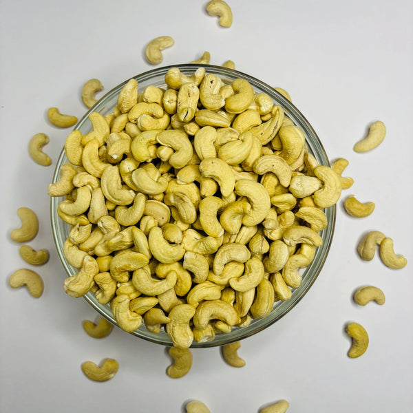 Glass bowl filled with cashews on a light gray background