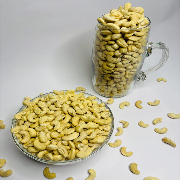 Cashews in a glass bowl and jar on a white background