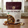 Nuts For Wellness Premium healthy trail mix 500g package on a wooden surface with visible ingredients.