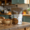 Bag of premium almonds on a kitchen counter with a bowl of almonds.