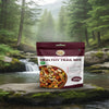 Nuts For Wellness Package of premium healthy trail mix on a rock with a forest background