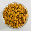 Glass bowl filled with almonds on a white background
