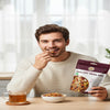 Man enjoying a healthy snack with a package of trail mix and a cup of tea.