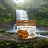 Bag of almonds on a rock with a waterfall and lush greenery in the background